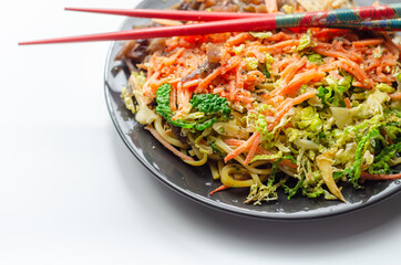 Cooked chicken breast pieces with egg noodles, carrots, and cabbage in a savory chow mein sauce