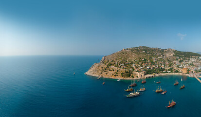 Aerial wide view of Alanya Turkey, Summer morning. Travel and vacation. Ships and boats. Kızılkule bay. lighthouse and pier. Copy space Show program and entertainment for tourists, swimming