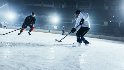 Ice Hockey Rink Arena: Two Professional Players From Different Teams Fighting for the Puck with Stick During Championship. Athletes Play Intense Game Wide of Energy Competition. Low Dutch Angle Shot.