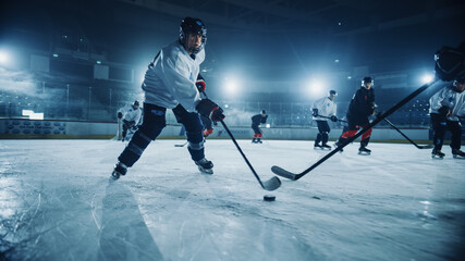 Ice Hockey Rink Arena: Professional Forward Player Masterfully Dribbles, Defend, Hitting Puck with Stick and Ready to Give Pass. Strong Performance Teams Play. Low Angle