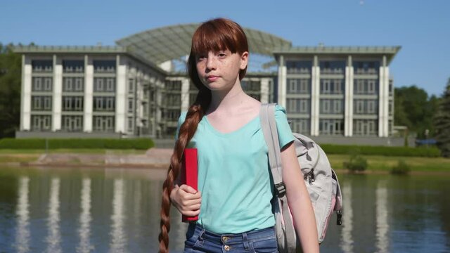 Medium shot of teenage girl with backpack and books on first school day walk in park