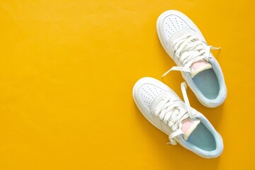 A pair of shoes isolated on yellow background. Top view. Flat lay.