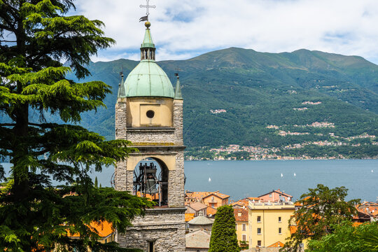 Bellano, lake Como, Lombardy, Italy. July 17, 2021. Editorial stock picture of the tower of the Parrocchia di Bellano church. The Como lake and the hills on the other shore can be seen in the backgrou