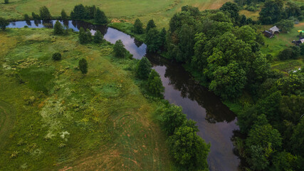 Aerial landscape of winding river in green field, top view of beautiful nature background from drone, seasonal summer landscape with copy space.