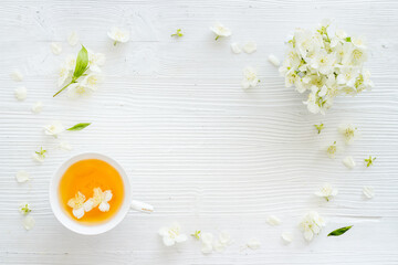 Cup of jasmine herbal tea with white flowers. Top view