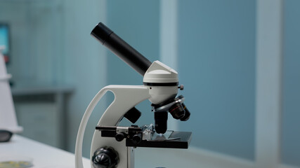 Scientific microscope in professional research laboratory on desk. Close up of magnifying glass instrument used in blood or dna examination industry. Biochemistry analysis modern tool