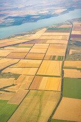 Land view through the airplane window. Fields, roads, rivers from a bird's eye view. Porthole. Look out the window of a flying plane. Top view of the ground