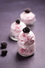 Blueberry and blackberry ice cream in bowl with frozen fruits