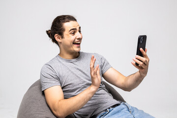 Happy man sit in bag chair do selfie shot on mobile cell phone isolated on white background