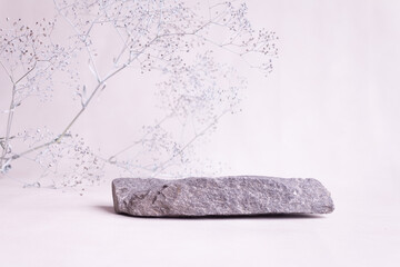stone with flowers on a light background. Catwalk for the presentation of products and cosmetics.