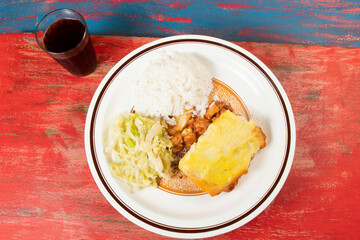 mashed potato pie with chicken and sautéed cabbage leaves and accompanying rice