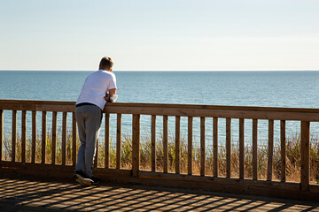 Hombre joven mirando el mar al atardecer.