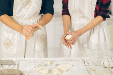 woman kneading dough on kitchen board