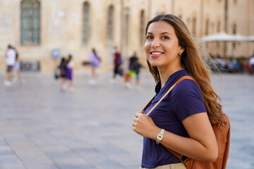 Cultural trip in Europe. Attractive girl strolling alone in historic european city.