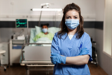 Portrait of woman working as nurse at clinic in hospital ward looking at camera with uniform and...