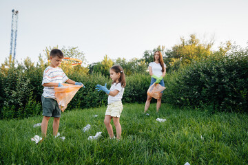 A group of girls with children at sunset are engaged in garbage collection in the park....