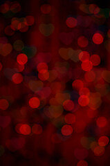 Red glitter vintage lights background with hearts. Defocused glittering lights background. Bokeh lights over dark background