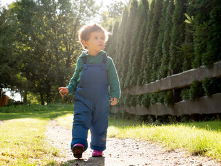 little boy overalls play in the garden