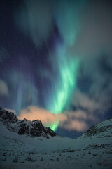 Northern lights, Aorora Borealis with starry over snow covered mountain peak at night