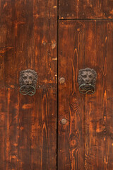 metalowe kołatki na starych drewnianych drzwiach