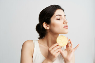 woman in a white t-shirt with a sponge in her hands clean skin of the face