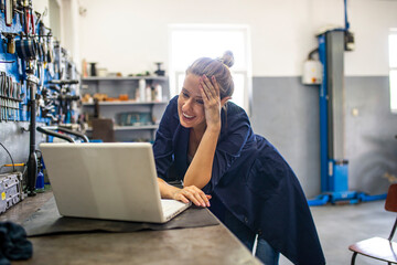 Female Mechanic. Female mechanic with laptop. Young female mechanic with laptop. Business woman at...