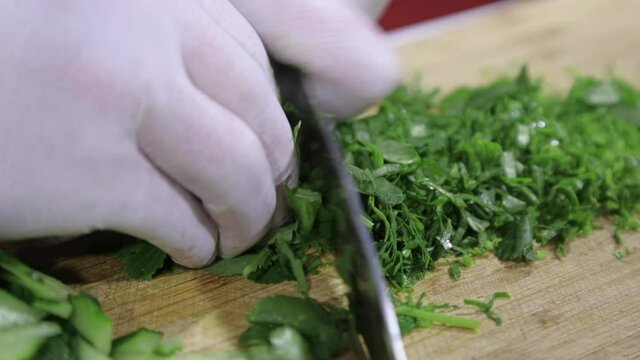 Freshly chopped green coriander on a light wood chopping board with a  mezzaluna herb chopper Stock Photo - Alamy