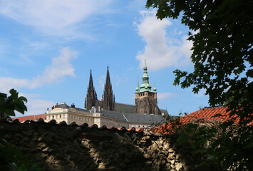 The majestic Cathedral of St. Vitus (Katedrála svatého Víta) on the background of a cloudy sky, in the rays of sunlight