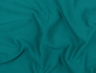 Turquoise jersey fabric matte texture top view. Blue knitwear background. Fashion color trendy...
