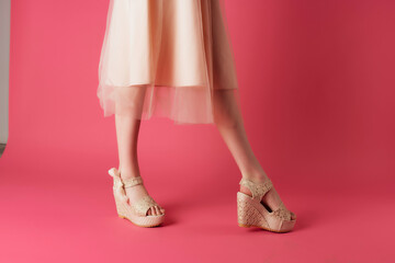 female legs in shoes dress cropped view pink background posing