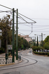 Athens, Greece - September 24, 2019: Acropolis hill view from streets of Athens with tram railway on Leof. Vasilissis Olgas. Ancient landmark in city center on cloudy day. Vertical