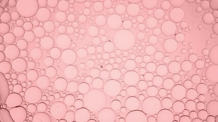 Big clear bubble moves along pale pink smaller ones moving them and explodes on pale pink background | Macro shot of moisturizer with glycerin for its commercial