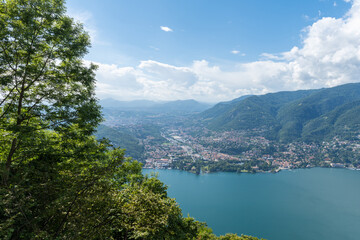 Fototapeta na wymiar Beautiful view over Lake Como and the city of Tavernola, Lombardy, Italy. The view is seen from the small village of Brunate, above the city of Como. It is a sunny, summer day