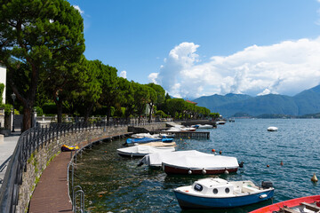 Fototapeta na wymiar View over the beautiful, gorgeous lake Como seen from the village of Lenno. It is a beautiful sunny summer day, with blue sky and a few clouds. There are boats on the lake