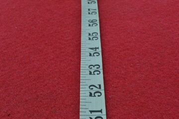 White tape measure on a red background with the numbers 52