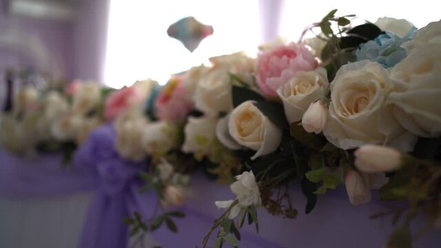 Flower decoration of the wedding table in the banquet hall. Close-up. Slow motion.