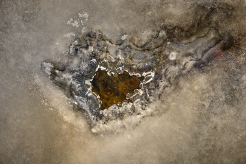 Hole in the ice and stones under the water