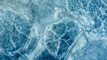 Beautiful ice texture with cracks of a frozen puddle on the asphalt for 3d texturing or design.