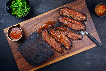 Modern style traditional smoked barbecue wagyu beef brisket with baby broccoli served as top view...