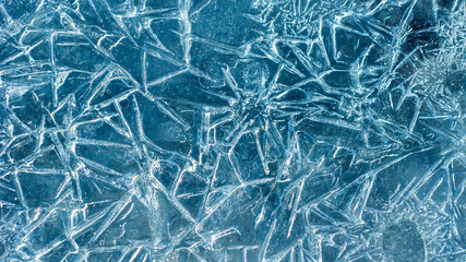 Beautiful ice texture with cracks of a frozen puddle on the asphalt for 3d texturing or design.