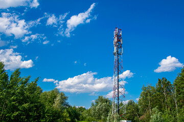 Obraz premium Telecommunication tower of 4G and 5G cellular. Macro Base Station. 5G radio network telecommunication equipment with radio modules and smart antennas mounted on a metal against cloulds sky background.