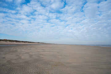 Low tide period on yellow sandy beach in small Belgian town De Haan or Le Coq sur mer, luxury vacation destination, summer holidays