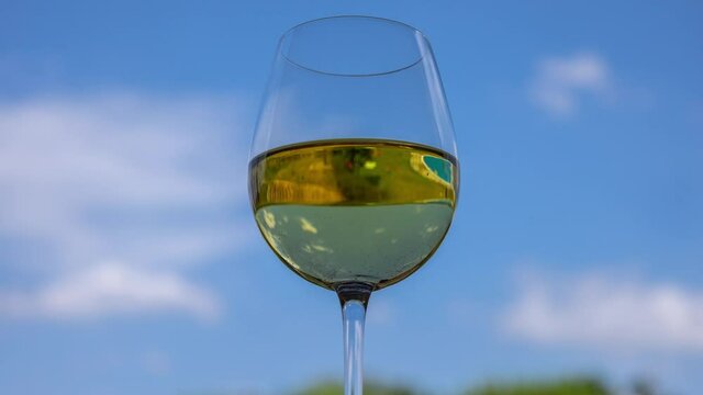 Glass of white wine against blue sky