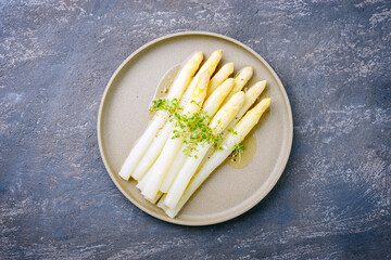 Modern style traditional steamed white asparagus with butter sauce hollandaise and cress served as...