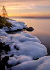 sunrise over the lake with ice covered stones 