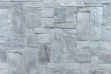 stone wall made of granite blocks of different sizes as the background