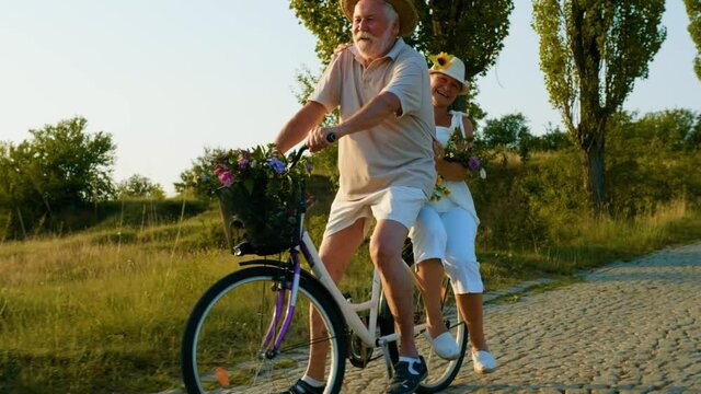 Mature grandparents cycling and having fun on bikes