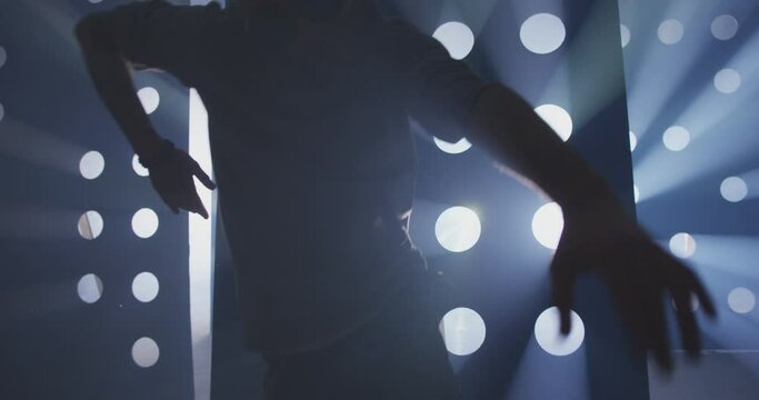 4K Professional Hip Hop , freestyle or swag dancer . Stylish young man dancing near decorative walls with many circle holes and spotlight . Real decoration . Shot on RED HELIUM Camera in Slow Motion .