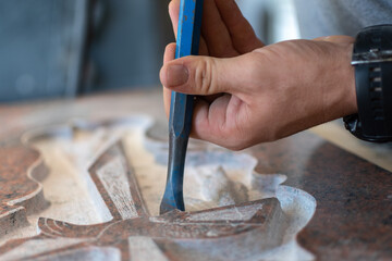 caucasian man hands bushhammered a tombstone in a workshop, work concept