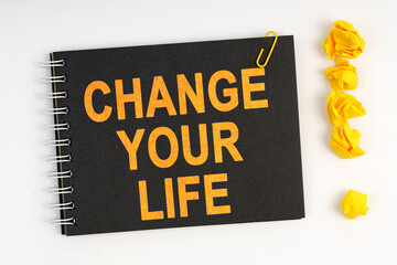 On the table is a marker, an exclamation mark and a notebook with the inscription - CHANGE YOUR LIFE